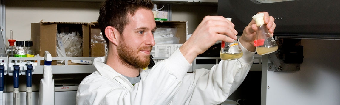 A scientist holds laboratory equipment